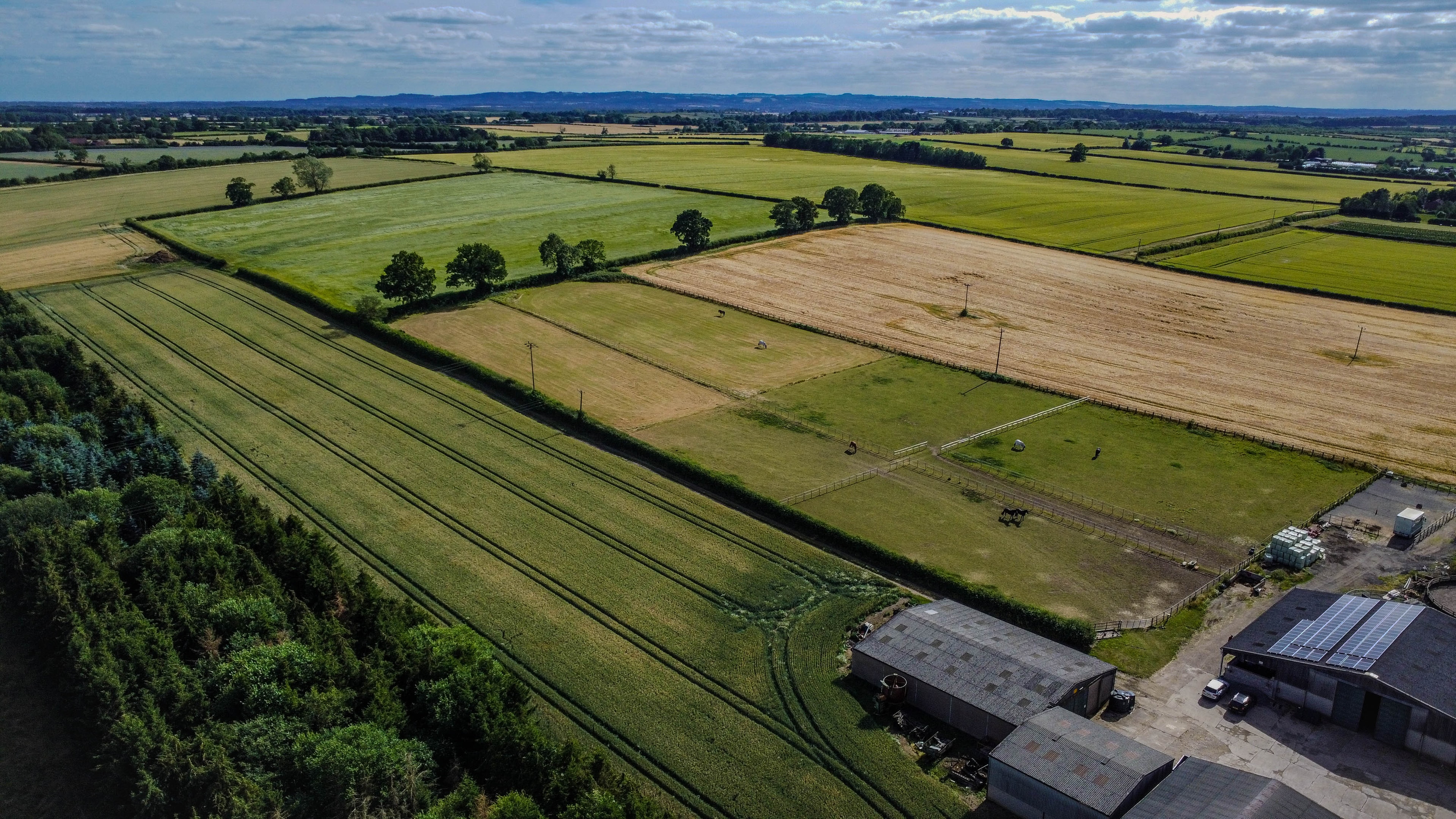 Aerial view of rural farmland with fields and farm buildings