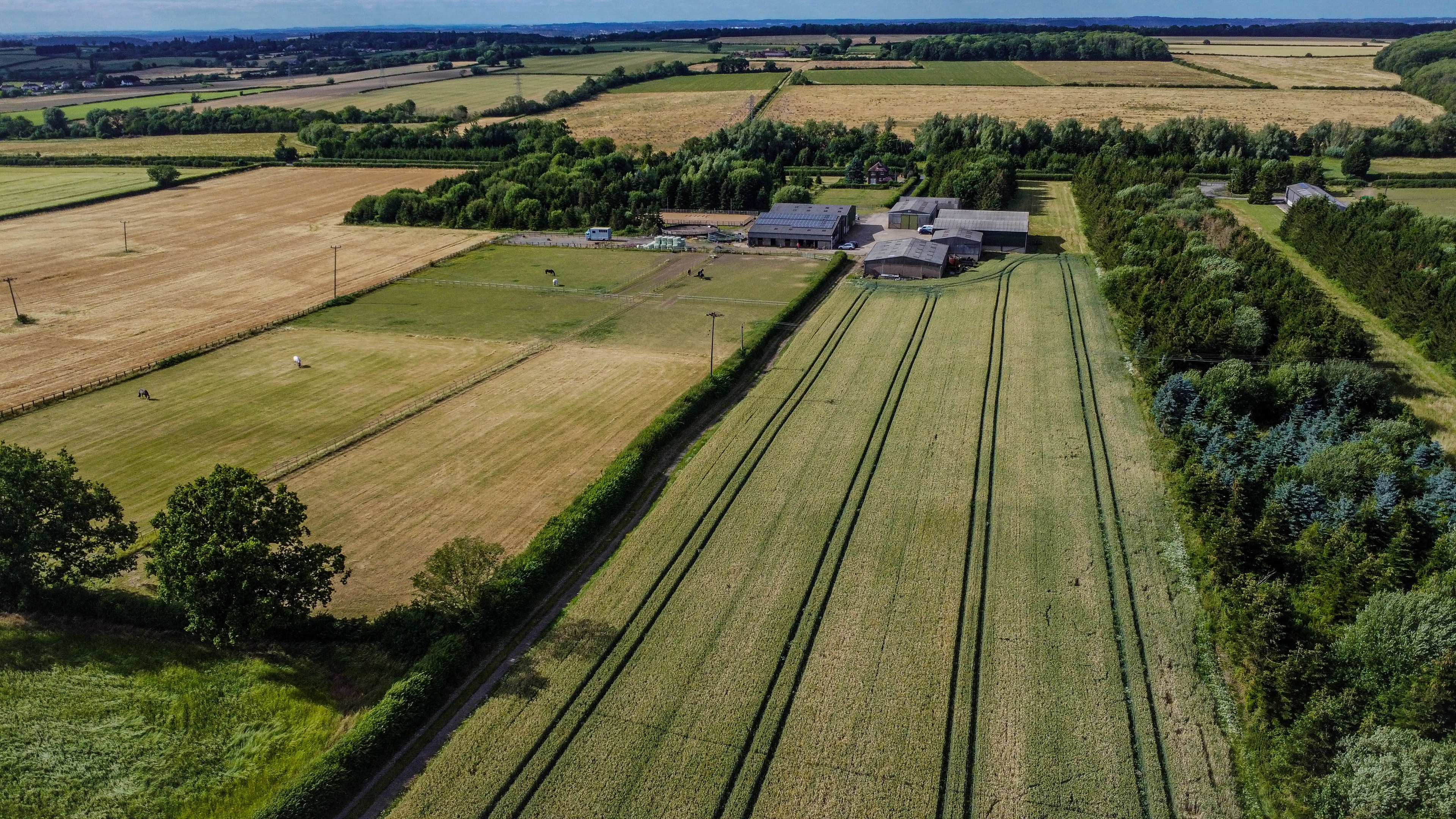 Aerial view of farm property with fields and surrounding landscape