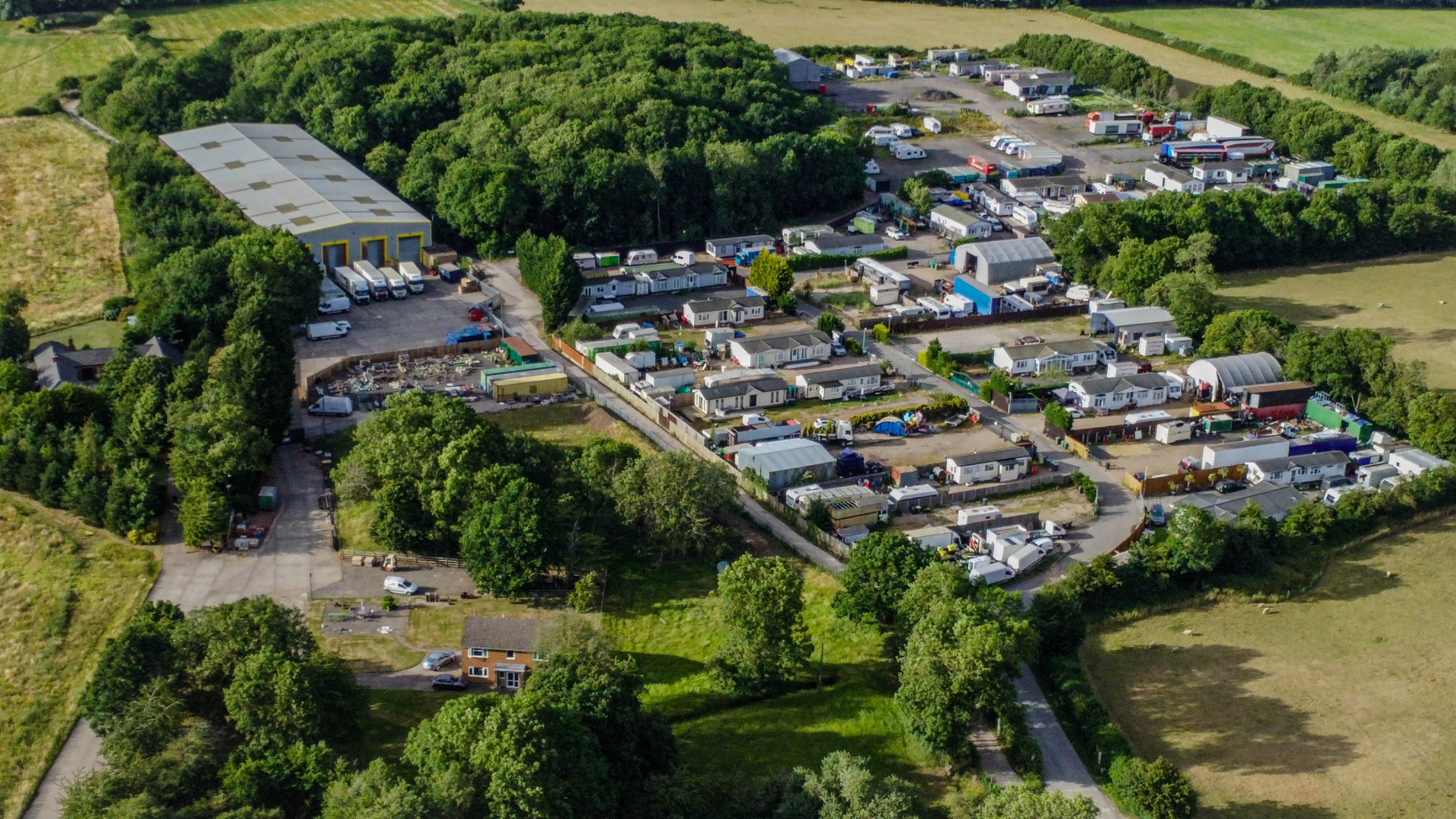 Aerial view of rural farm complex with fields and paddocks